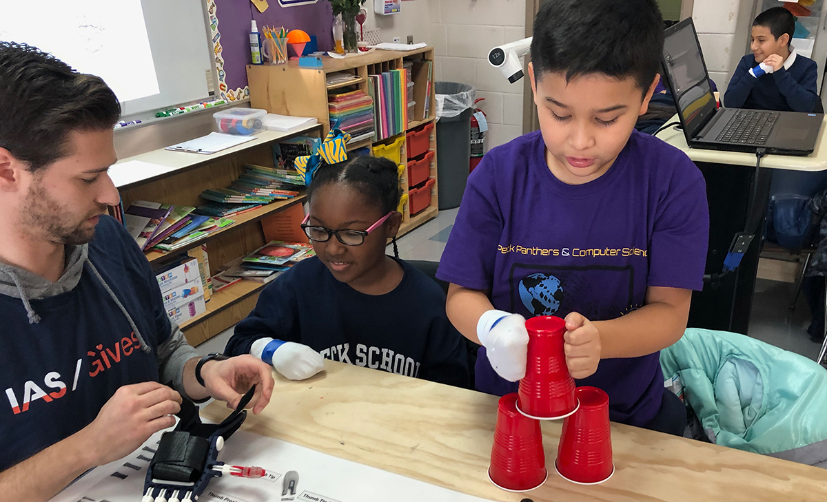 A Peck Elementary school student stacks cups with a socked hand to learn empathy for kids who have been born without the use of a hand or fingers.