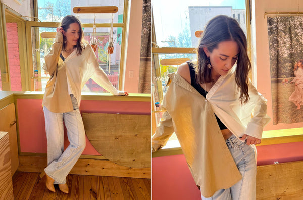 Haley wearing a collared button down top at our Hillsboro Village location. She is standing in the sun by a window and a pink wall.