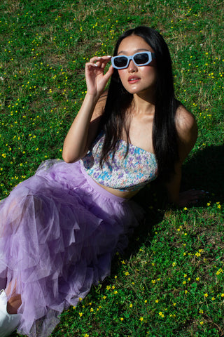 anabel wearing a purpel tulle skirt and a floral tube top and blue sun glasses