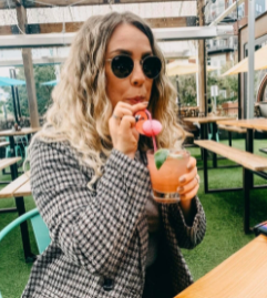 blonde girl with wavy hair and drink 
