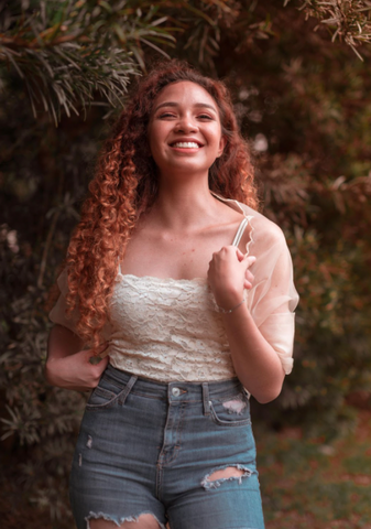 curly hair woman smiling outside