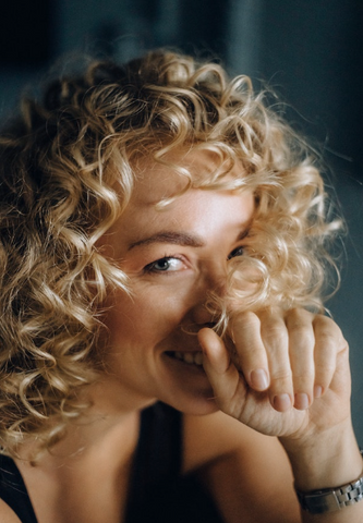 woman with blonde curly hair laughing 