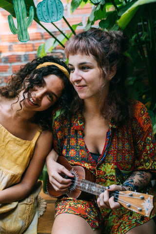 two women with curly hair and ukulele 