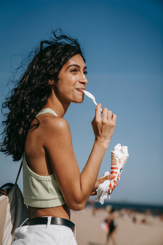 curly woman hair on beach with ice cream summer