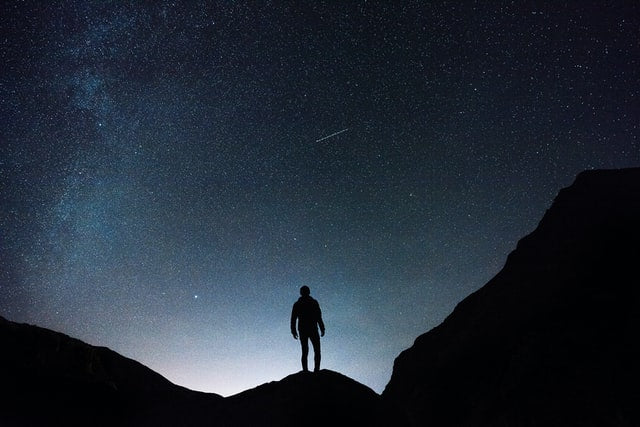 Mann beobachtet Sterne und Sternschnuppen
