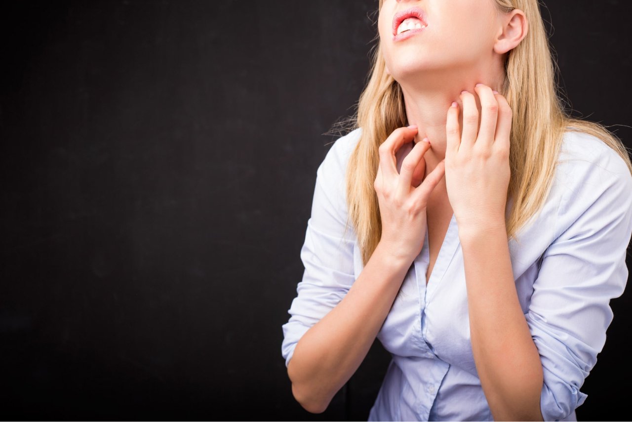 Businesswoman in white shirt scratching her neck with a discomfort expression against a dark background