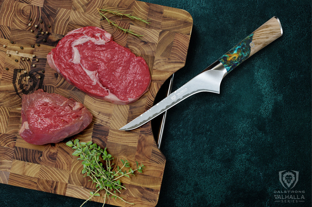 Valhalla boning knife beside steaks on a cutting board