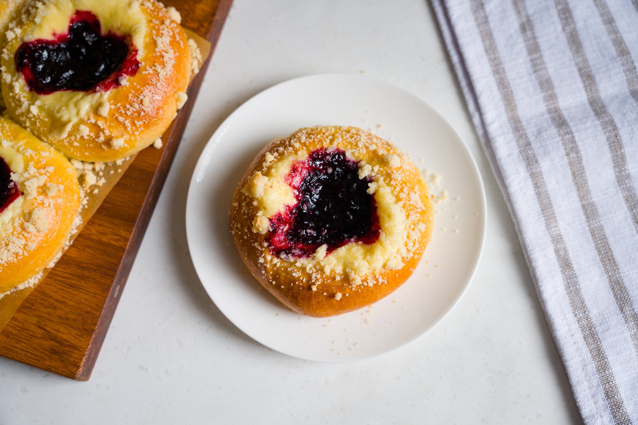 A single cherry cheese kolaches on a small white plate