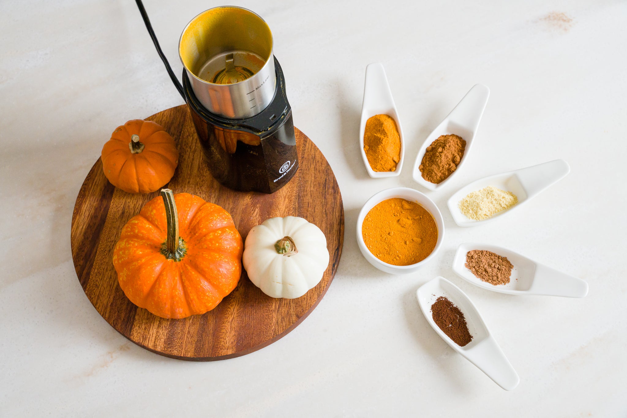 pumpkin spice ingredients next to a spice grinder