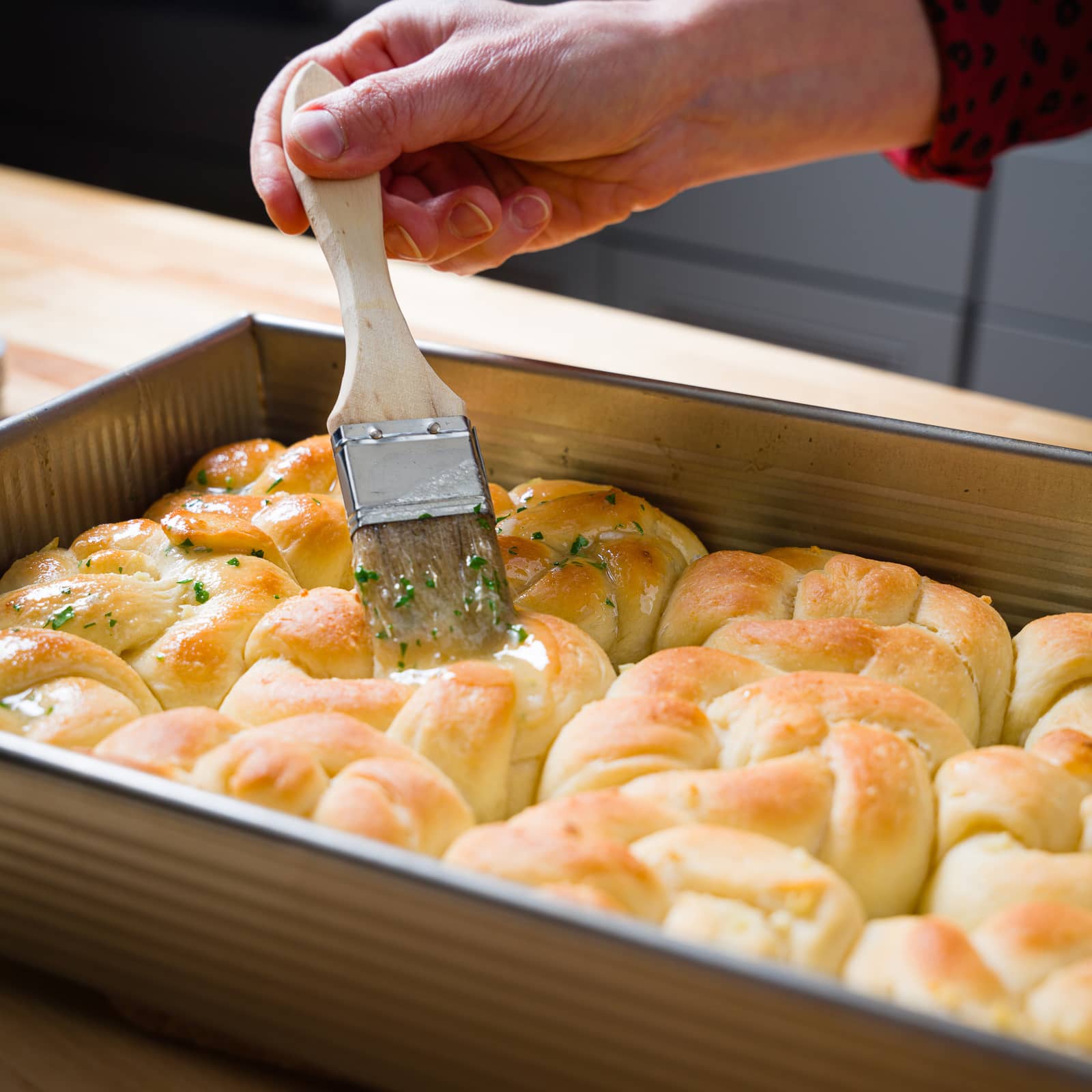 Brushing butter over the baked garlic knots