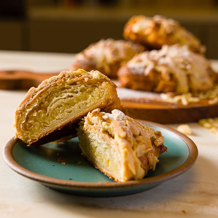 Croissants aux amandes, coupés en deux, sur une assiette