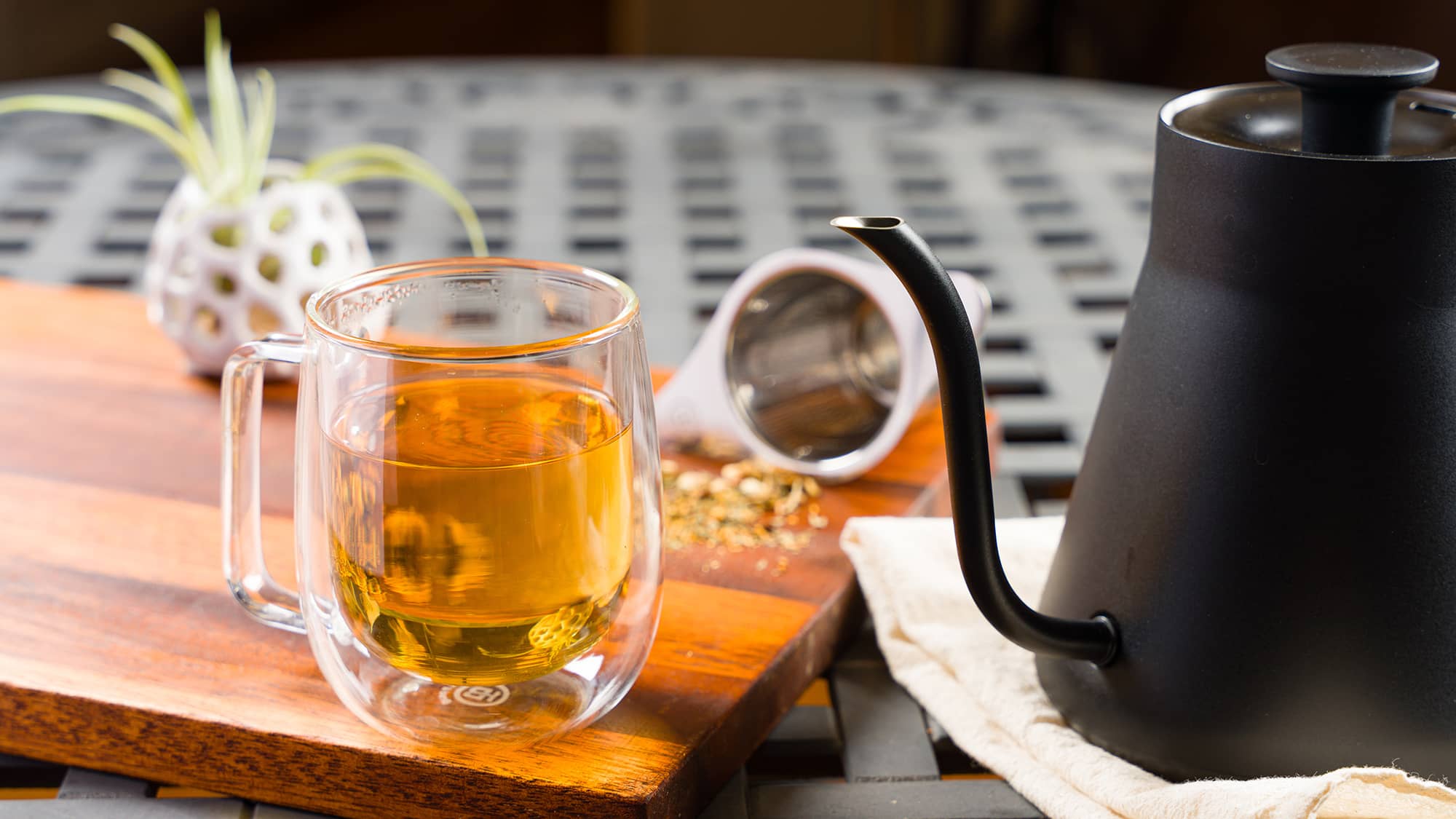 Homemade tea on a table with double walled glass tea mug.