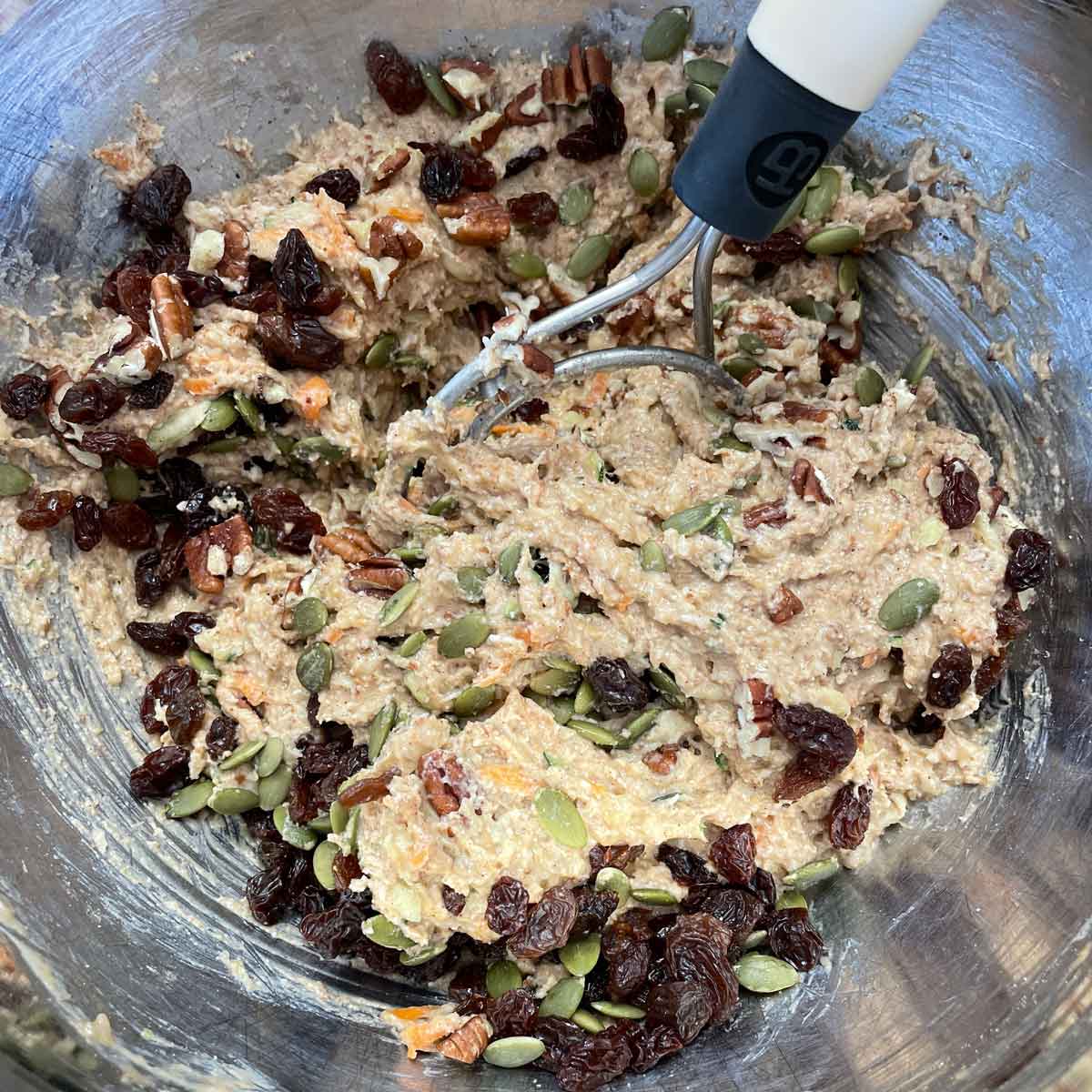 Adding fruit, nuts, and seeds into the whisked ingredients