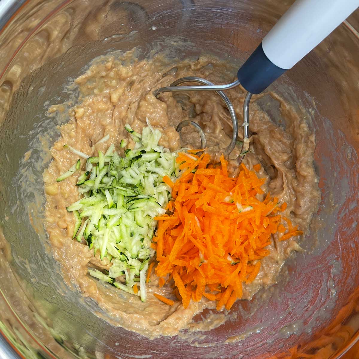 Adding shredded carrots and zucchini into the banana mix