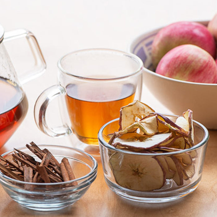 Dehydrated apple slices and apple tea in a glass mug