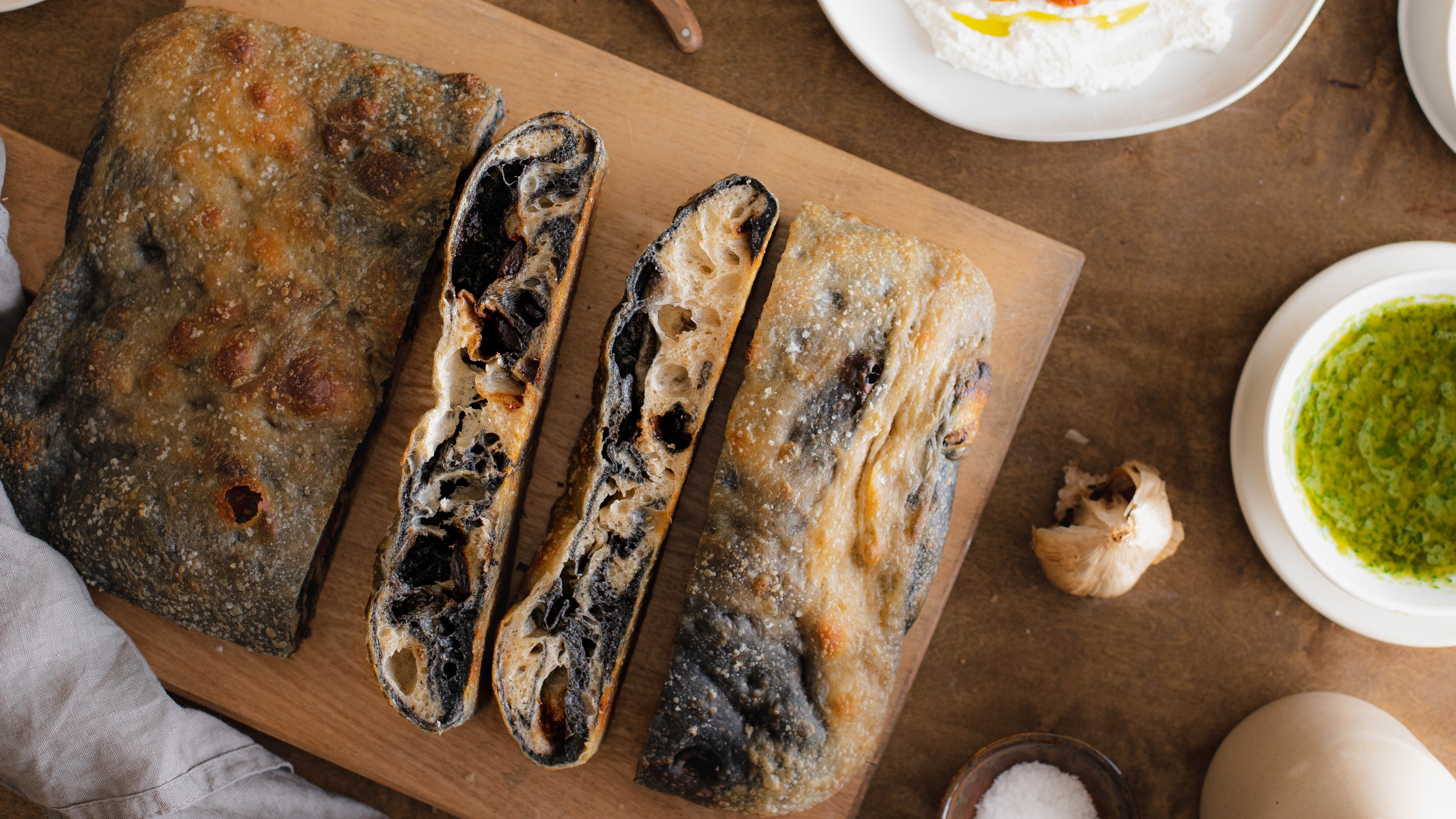 Sliced loaf of marbled black garlic focaccia