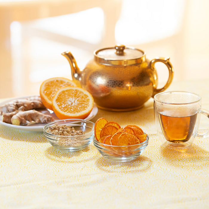 Dehydrated citrus and ginger slices, tea, and teapot