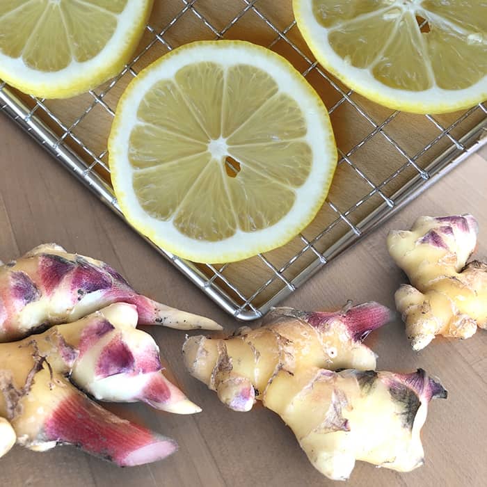 Fresh ginger roots and sliced lemon