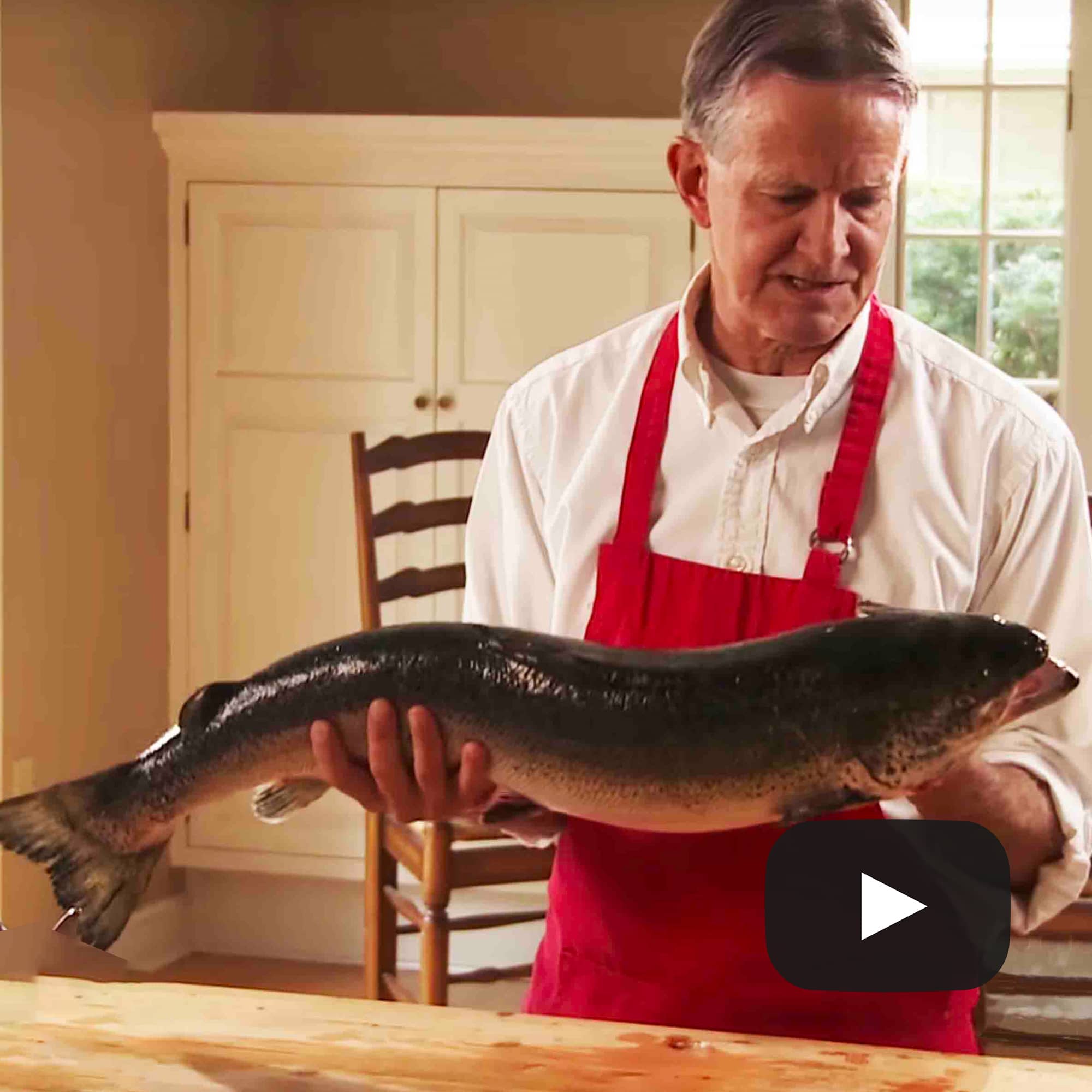 Whole salmon held by a chef