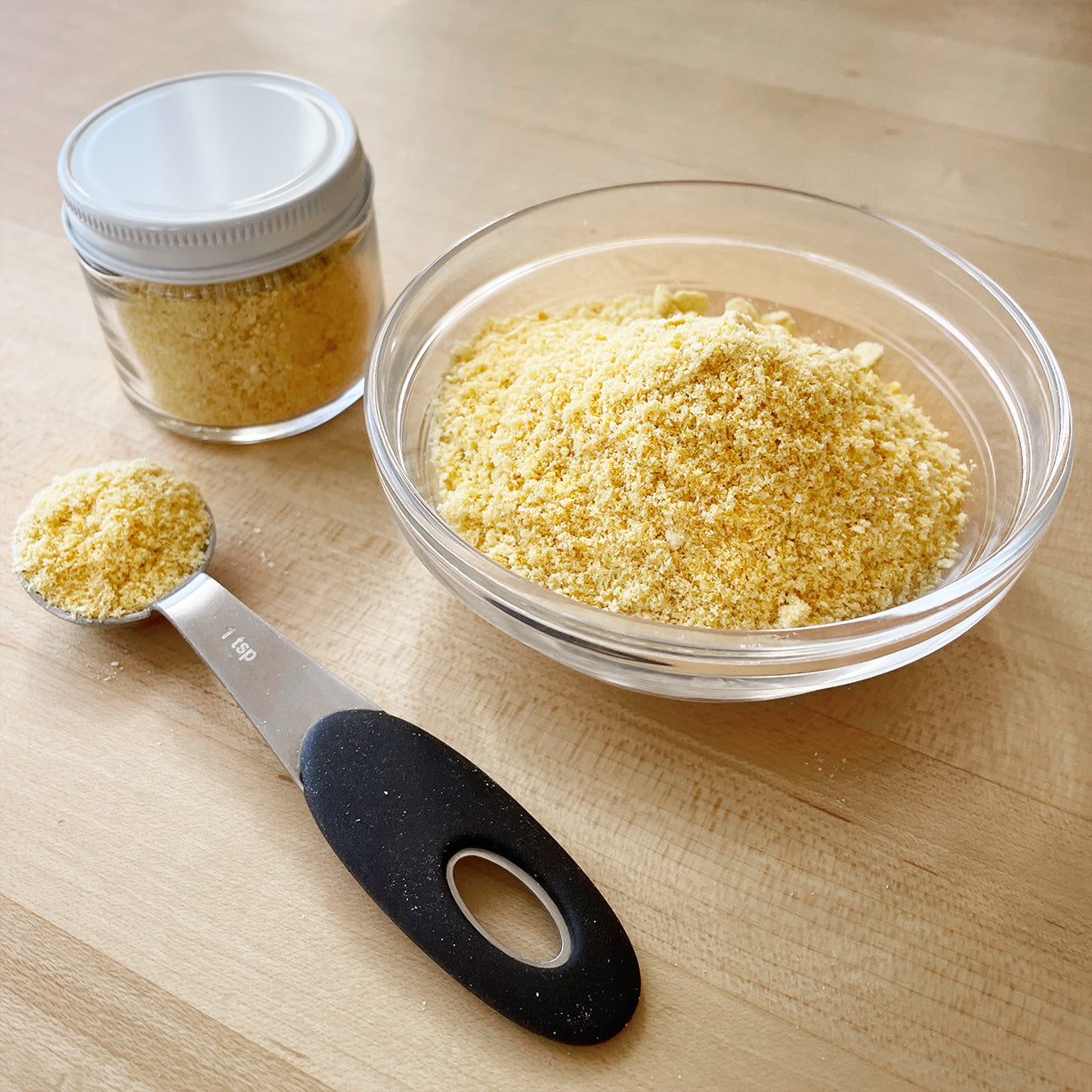 lemon powder in a bowl, jar and a measuring spoon