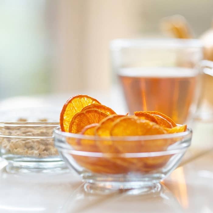 Dehydrated orange slices and tea in a glass mug