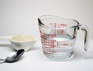 Hot water in a measuring cup and 1 cup of sugar