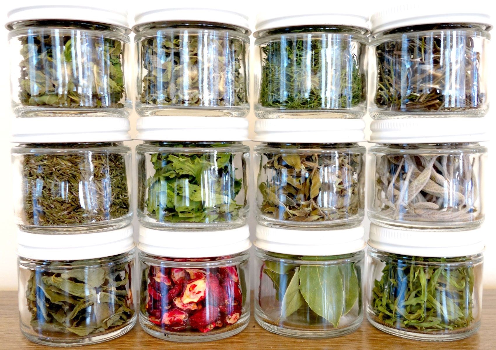 Various dried herbs in glass storage jars