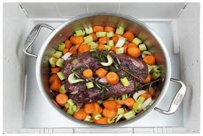 Chuck roast and chopped vegetables in a stainless steel pot placed in the proofer