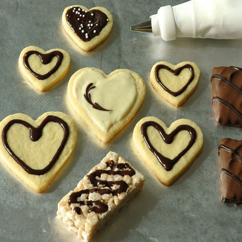 heart shaped cookies decorated with melted chocolate