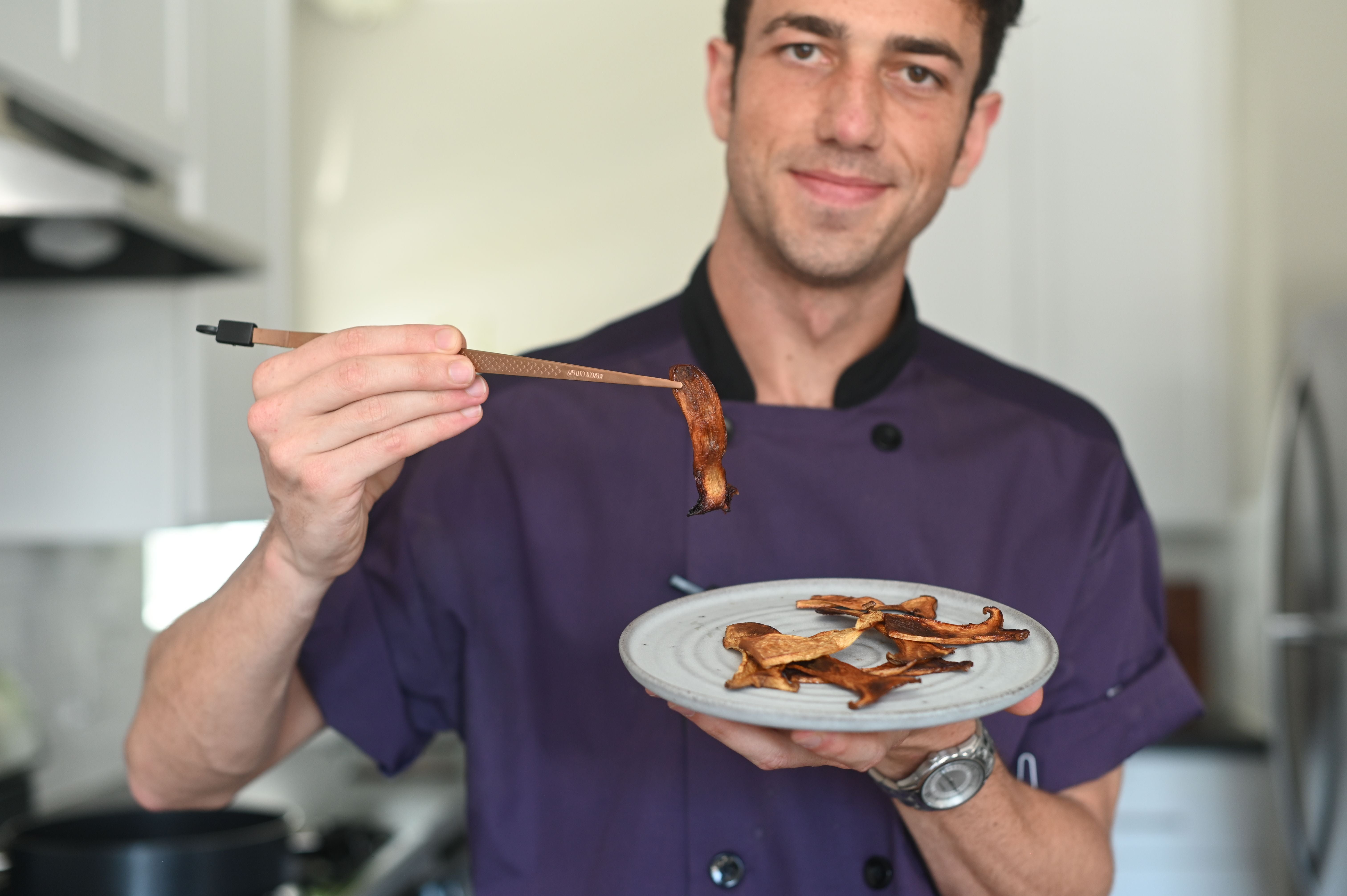 Mario Fabbri holding cooked mushroom bacon