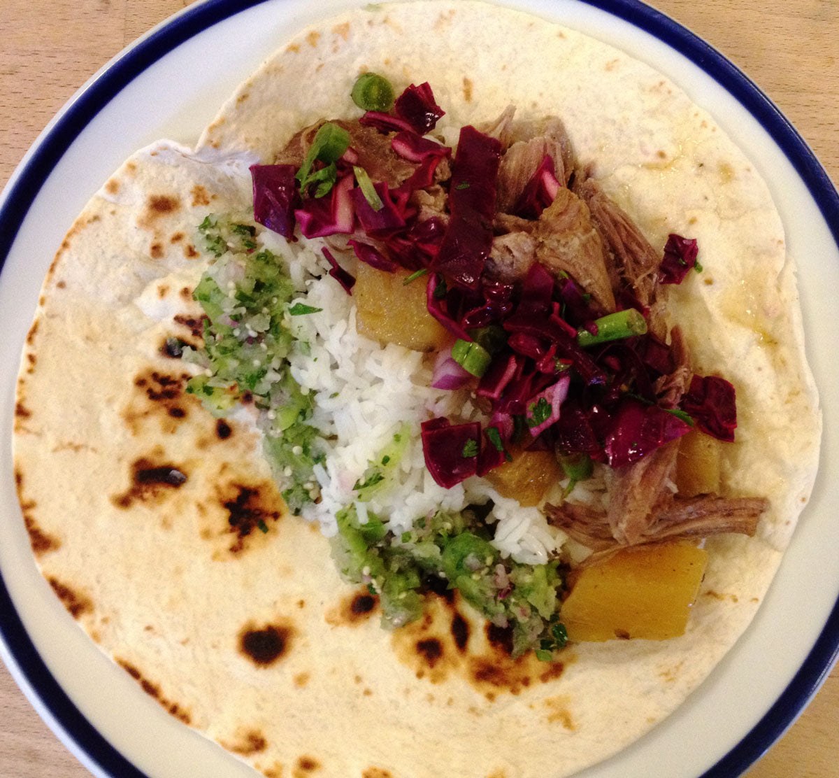 Pork Al Pastor served on a flour tortilla