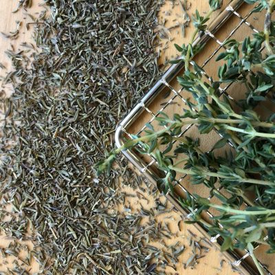 Fresh and dehydrated thyme on a dehydrator rack