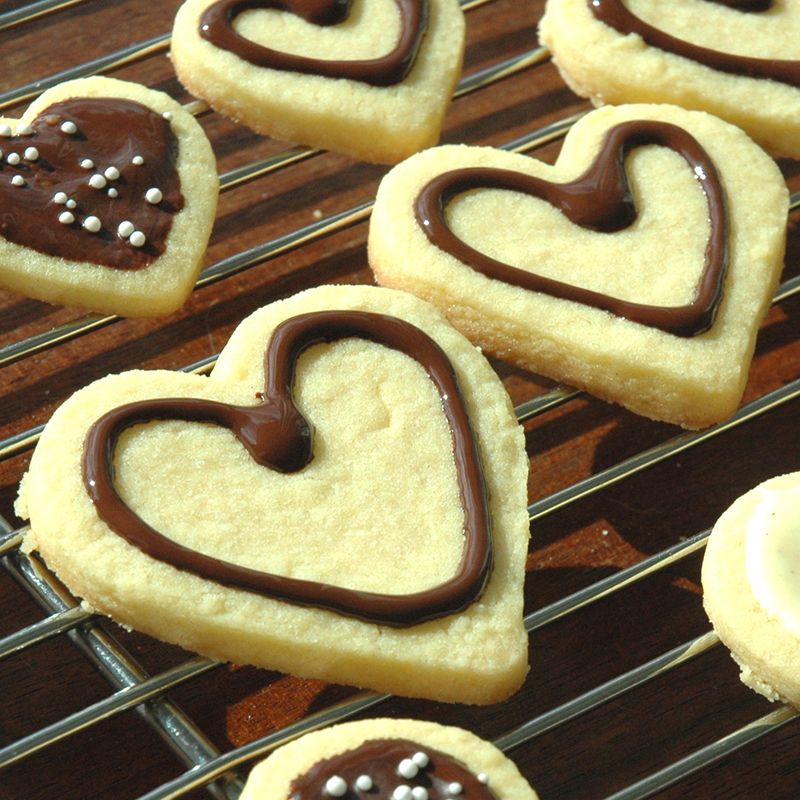 biscuits en forme de cœur décorés avec du chocolat blanc et du chocolat au lait fondus