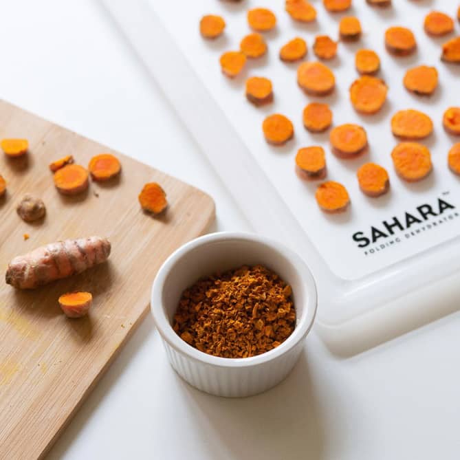 Chopped raw, dehydrated turmeric and turmeric powder in a bowl