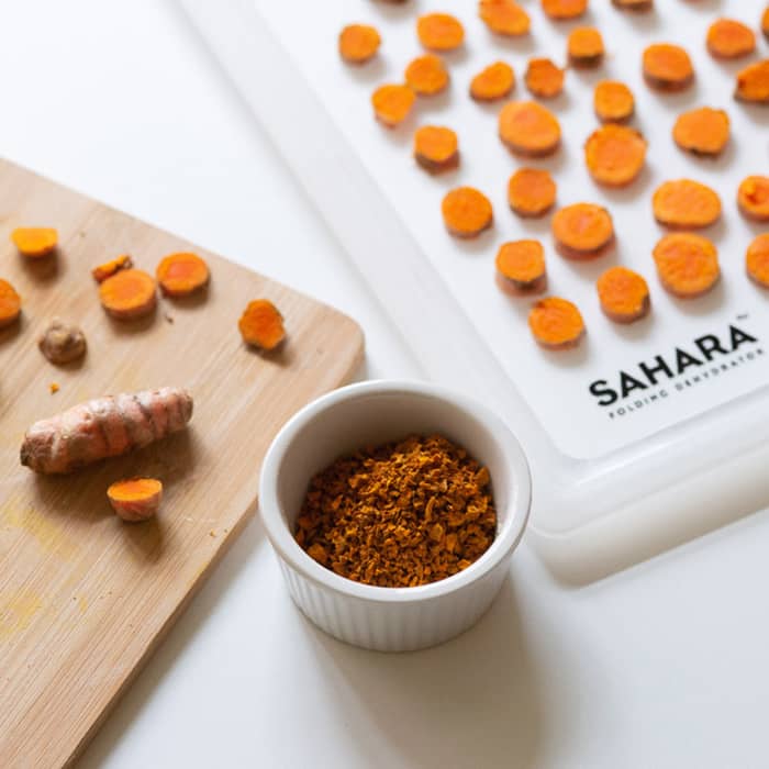 Fresh turmeric root and dehydrated turmeric in a bowl