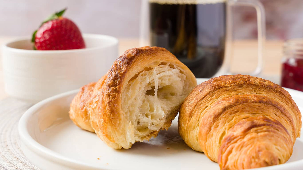 Croissant végétalien partagé sur une assiette.