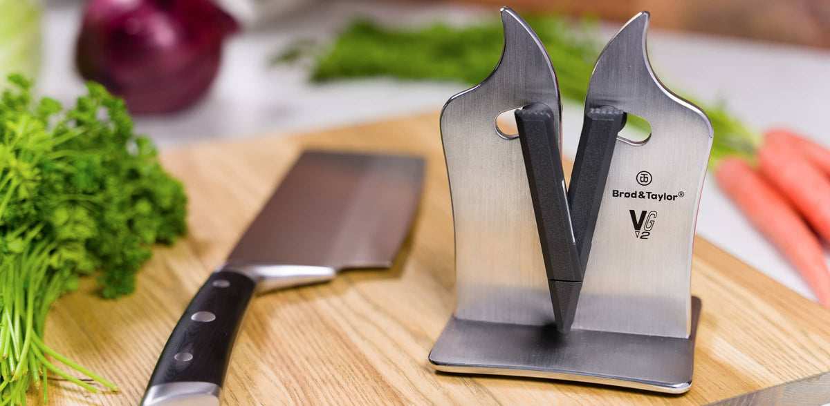 VG2 Pro Knife Sharpener on a cutting board with a knife and vegetables