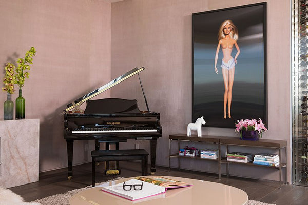 Barbie image on the wall beside wine cellar and grand piano