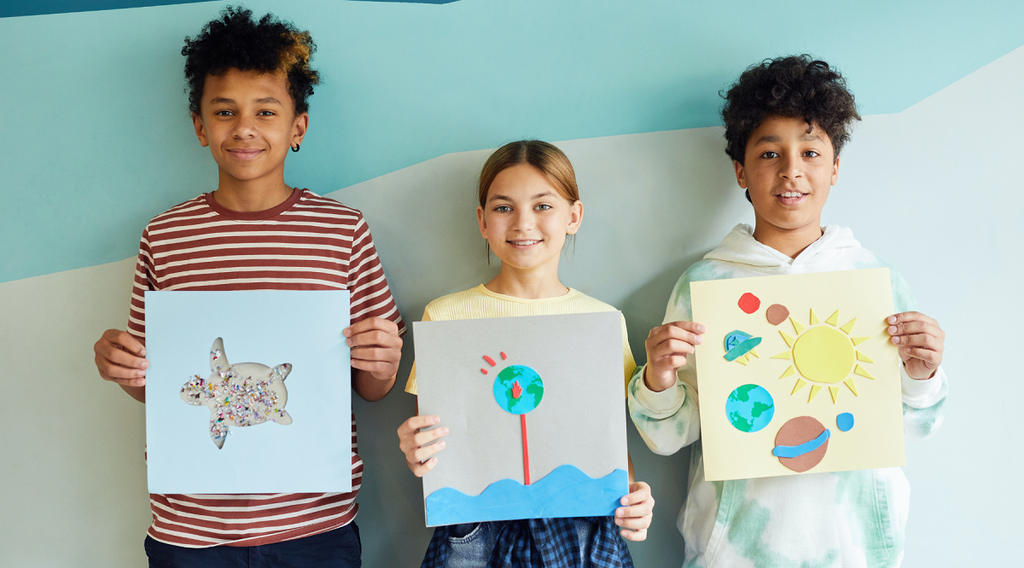 Three kids showing their artworks