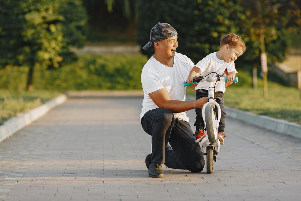 dad teaching his son to ride a bike