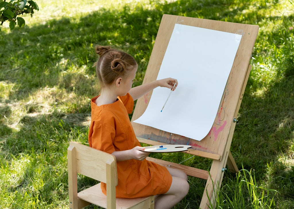 Little girl painting outdoors