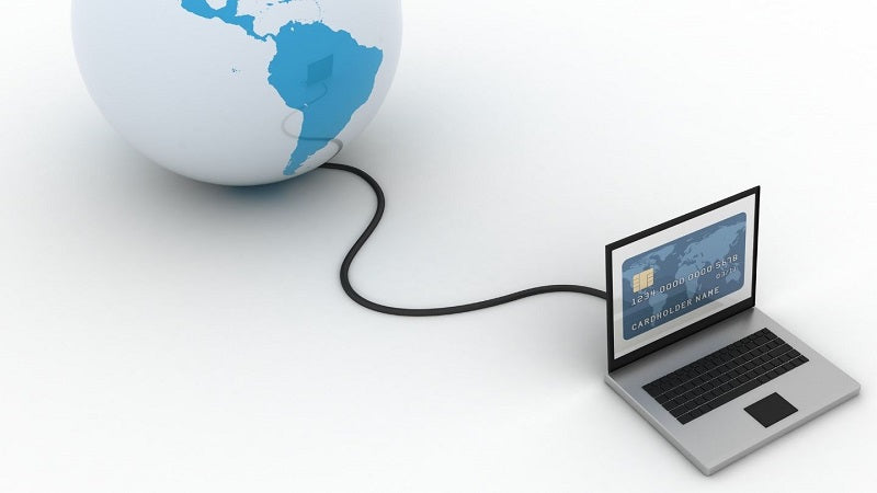 Un computador conectado a través de un cable a un globo terráqueo.