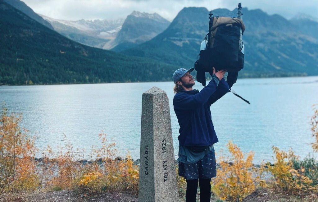 a hiker holding swift x by a lake