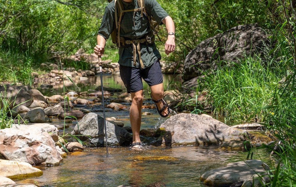 hiker crossing a river in hiking sandals