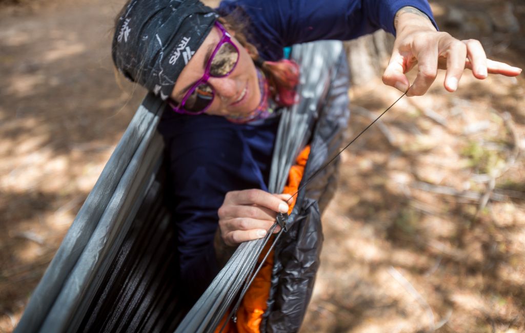 hiker adjusting hammock underquilt