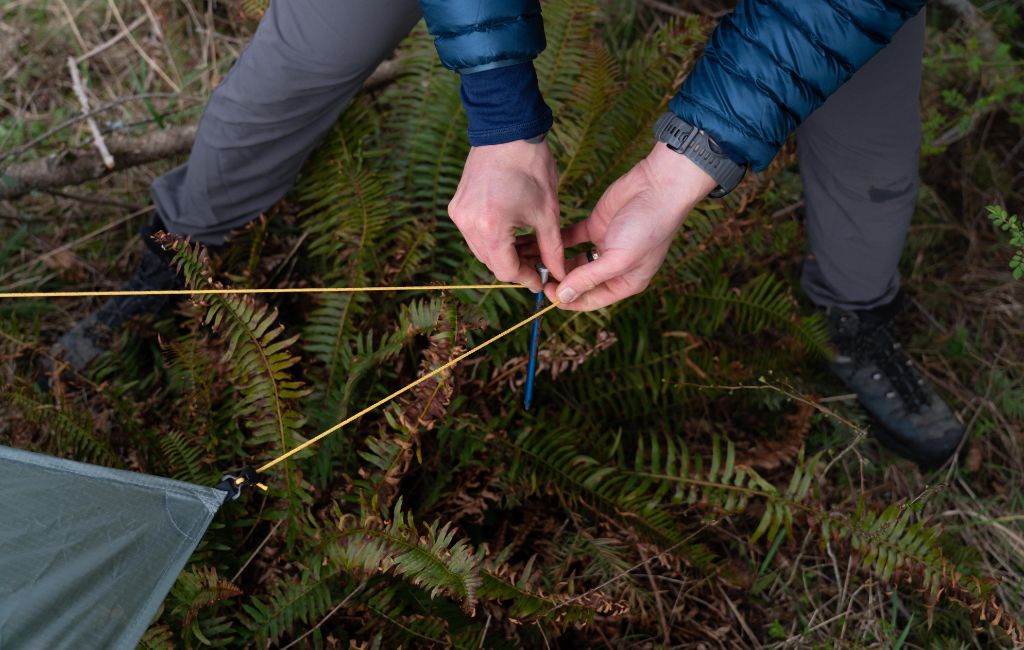 inserting tent stakes into ground