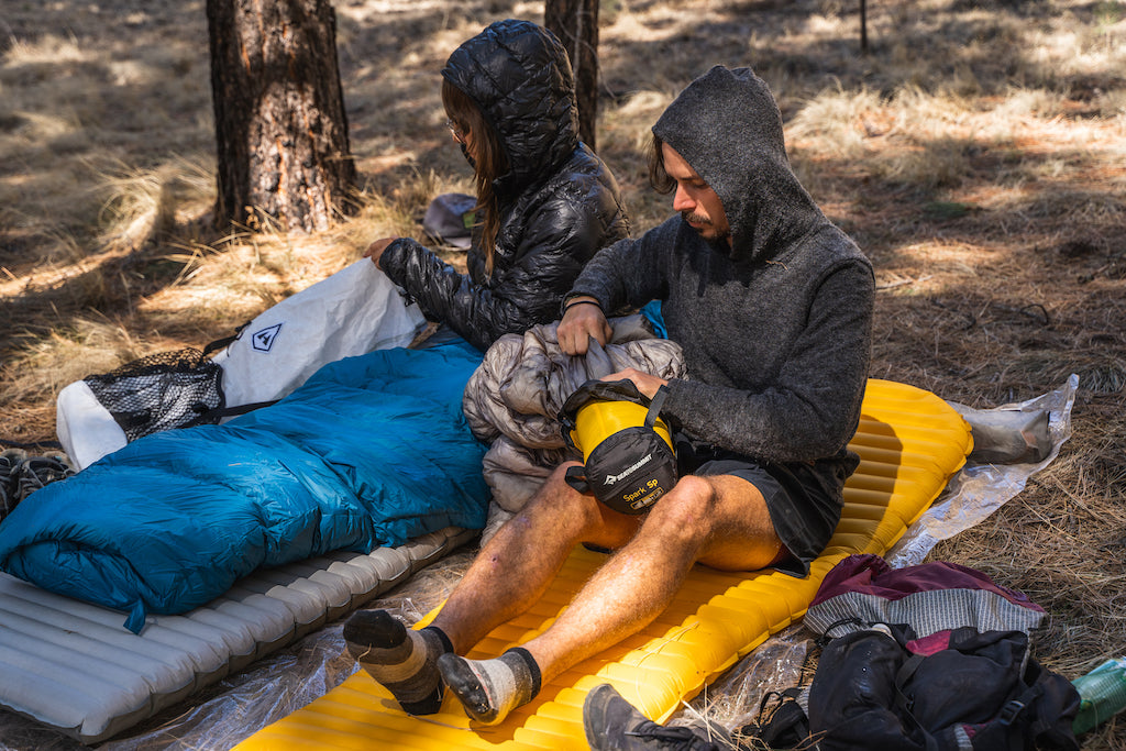 hikers cowboy camping in down sleeping bags