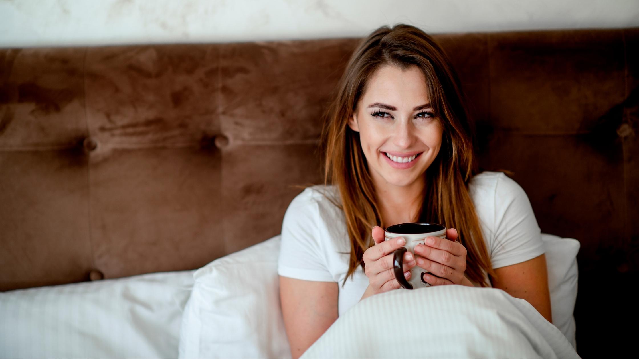 Woman drinking coffee in bed