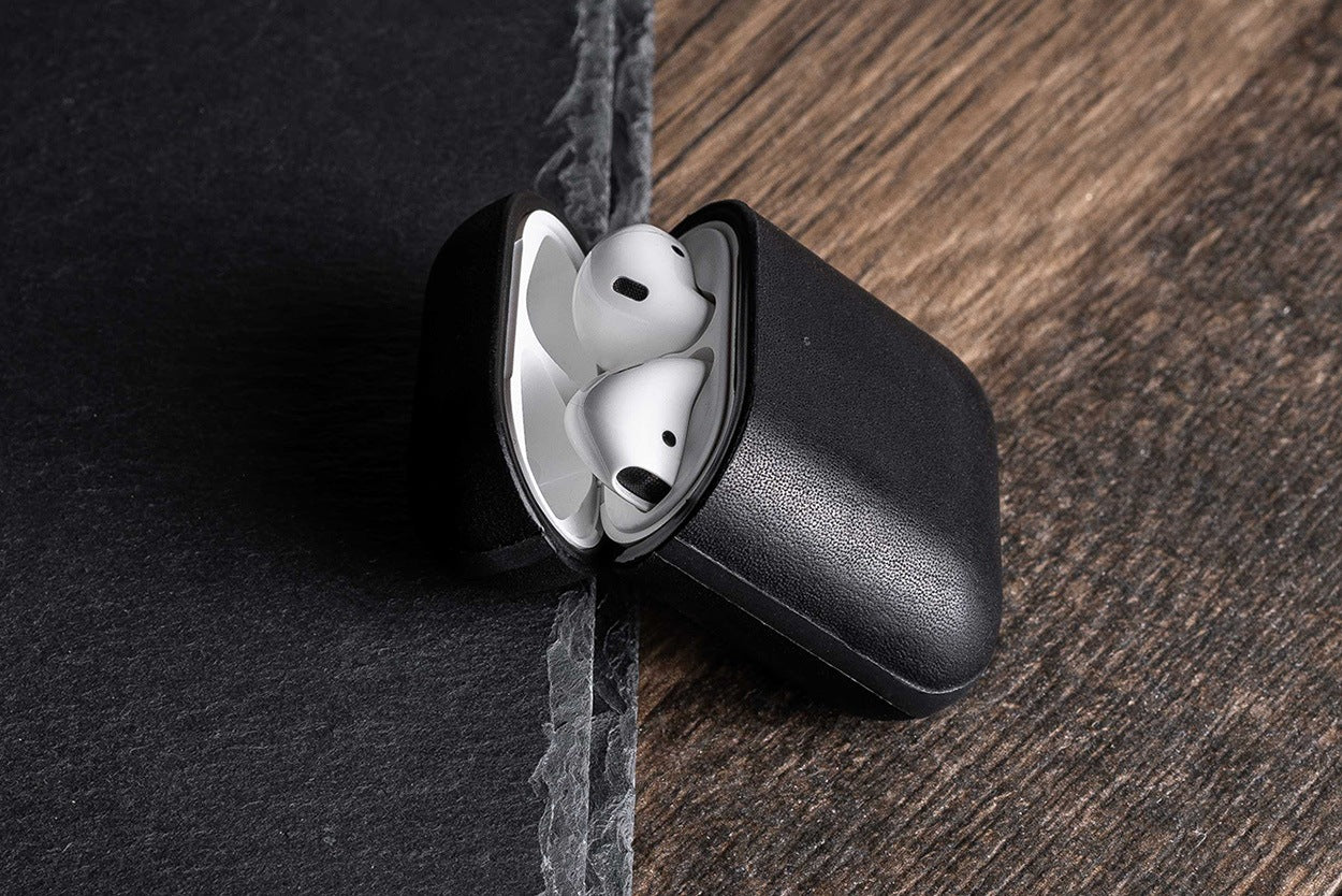 Open Rugged Case in Black displaying Apple AirPods leaning on slate stone.