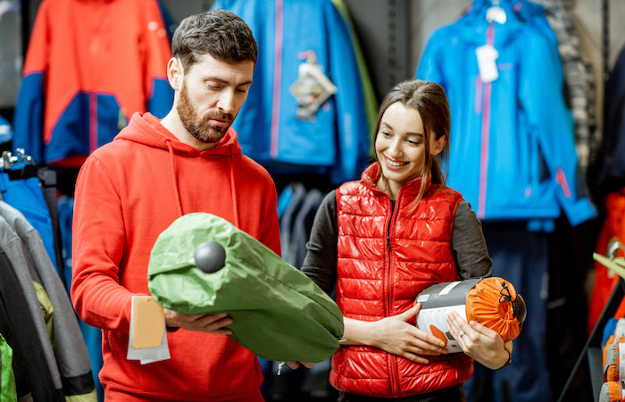 man and woman shopping for camping supplies